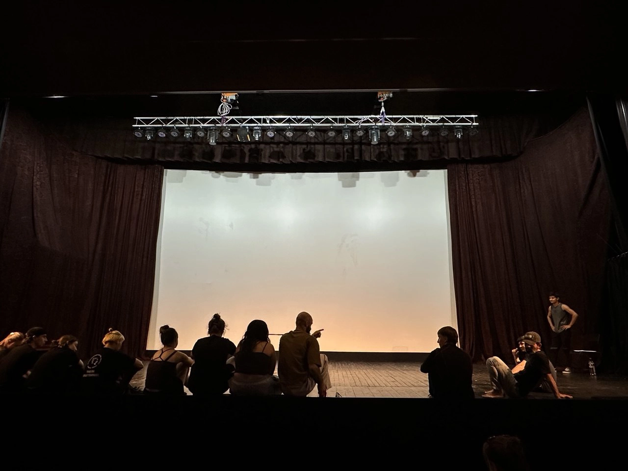 Felix Podborski conduce un exercițiu cu participanții așezați în cerc pe scena unui teatru.