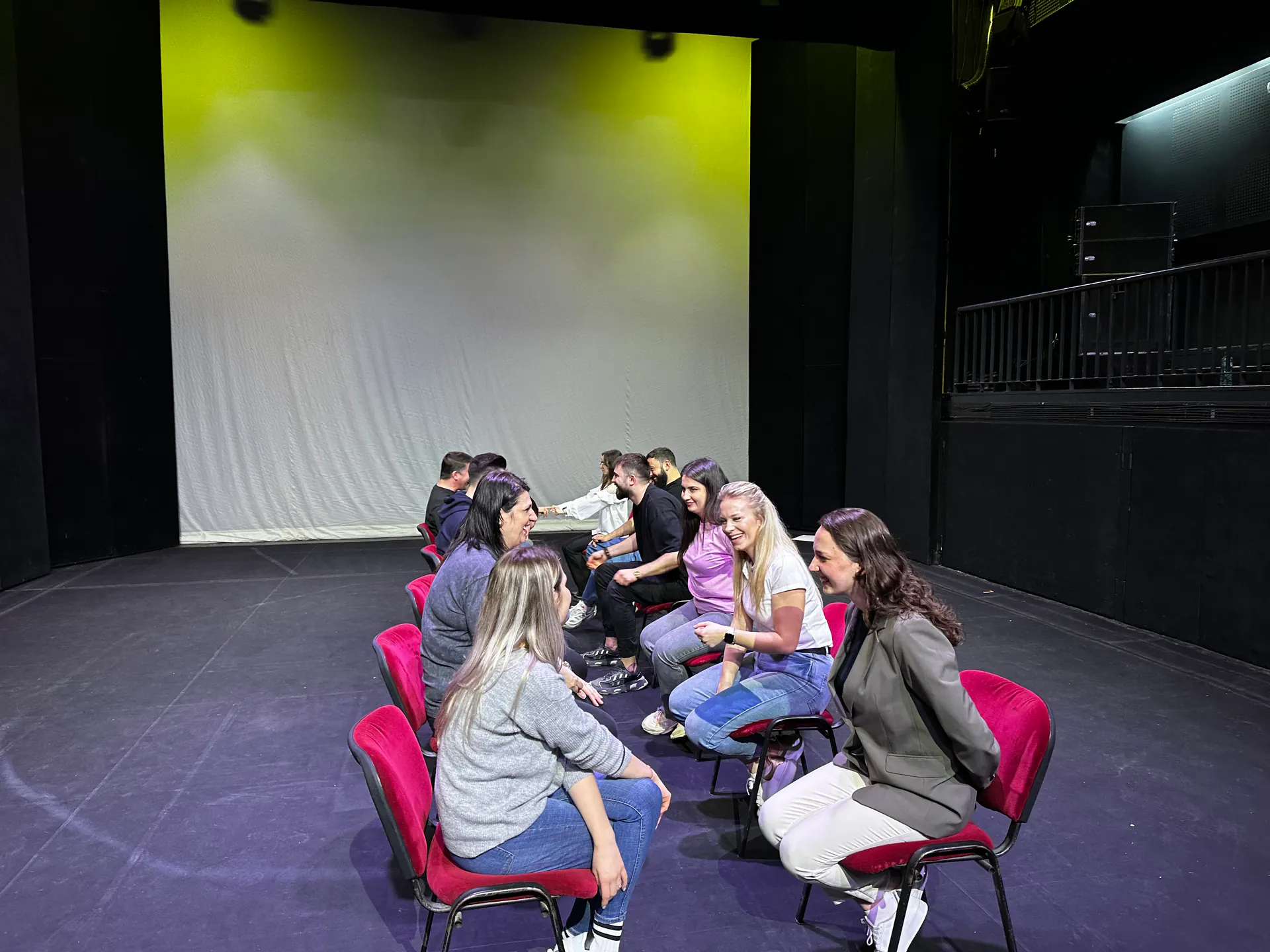 Felix Podborski lucrează cu o echipă de participanți pe scena unui teatru.